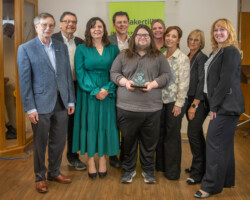 The committee and staff involved in organizing Easter Seals Snowarama proudly displayed the Community Merit Award sponsored by Sask Tel and presented by Leanne Woodhouse.